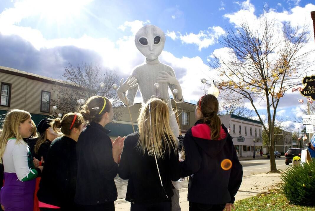 An alien puppet looms over a group of girls watching a UFO parade in Belleville, Wisconsin. Photo by Erik Lorenzsonn for WPR.